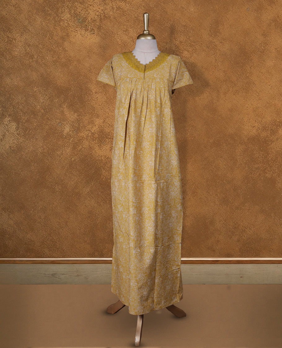 Mustard colour NStyle nighty featuring white floral patterns,a V neckline and thread lace border, short sleeves, and a full ankle-length design.