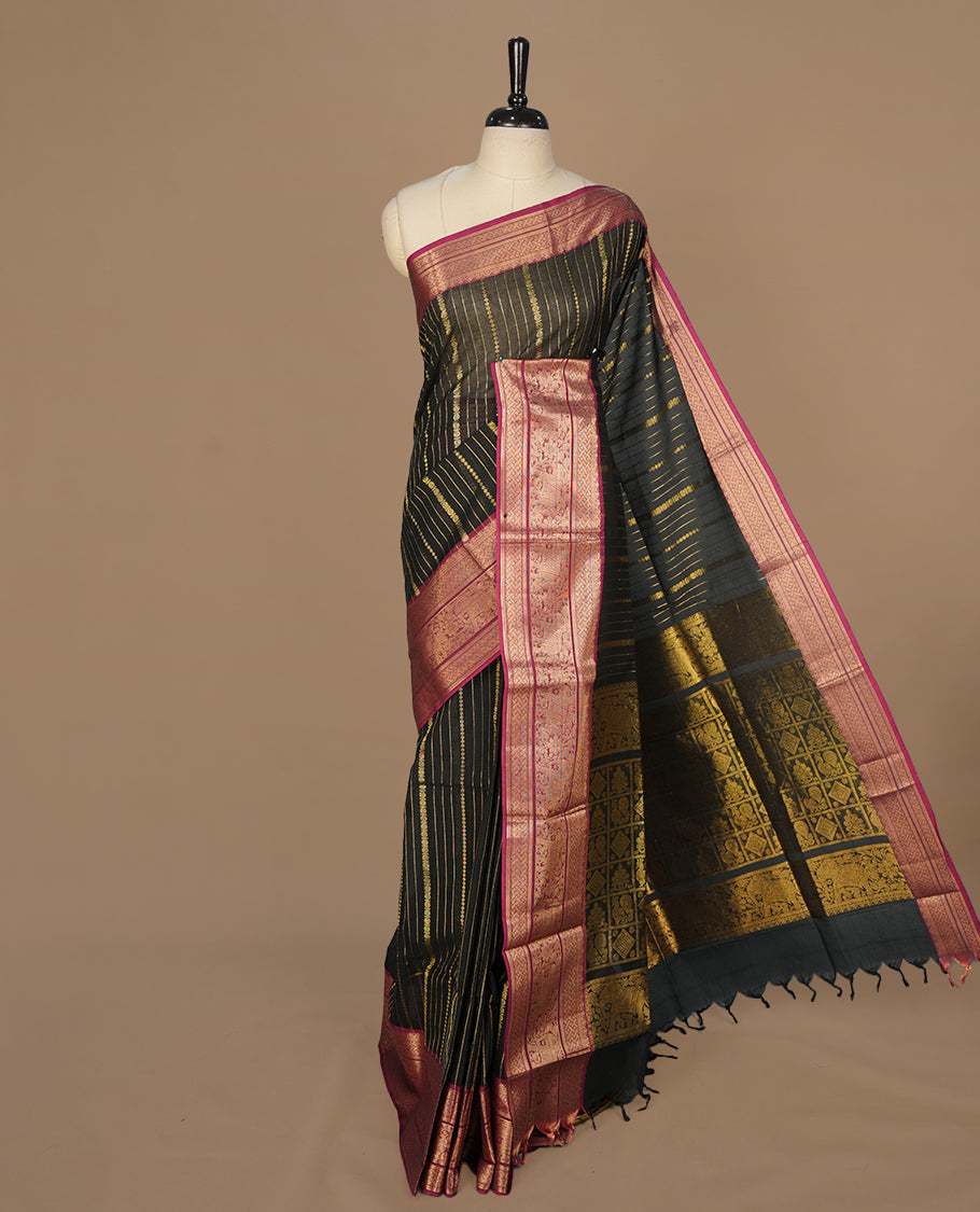 Black colour chettinad saree featuring gold zari stripes on body, complemented by contrast magenta colour with traditional border, paired with matching blouse piece.