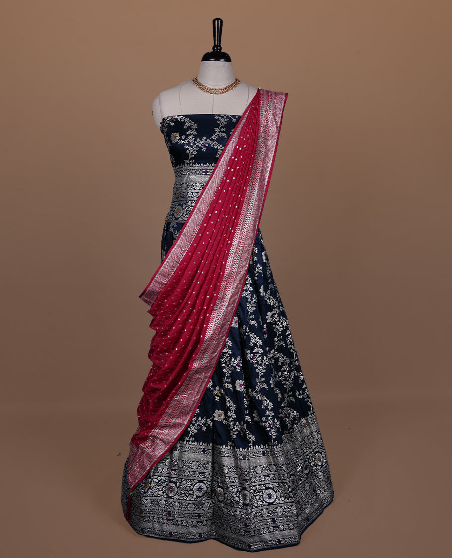 Teal colour semi banaras semi stitched dhavani set featuring gold zari floral kodi motifs and traditional border, unstitched matching blouse piece and contrast Red colour Duptta with silver zari border border.