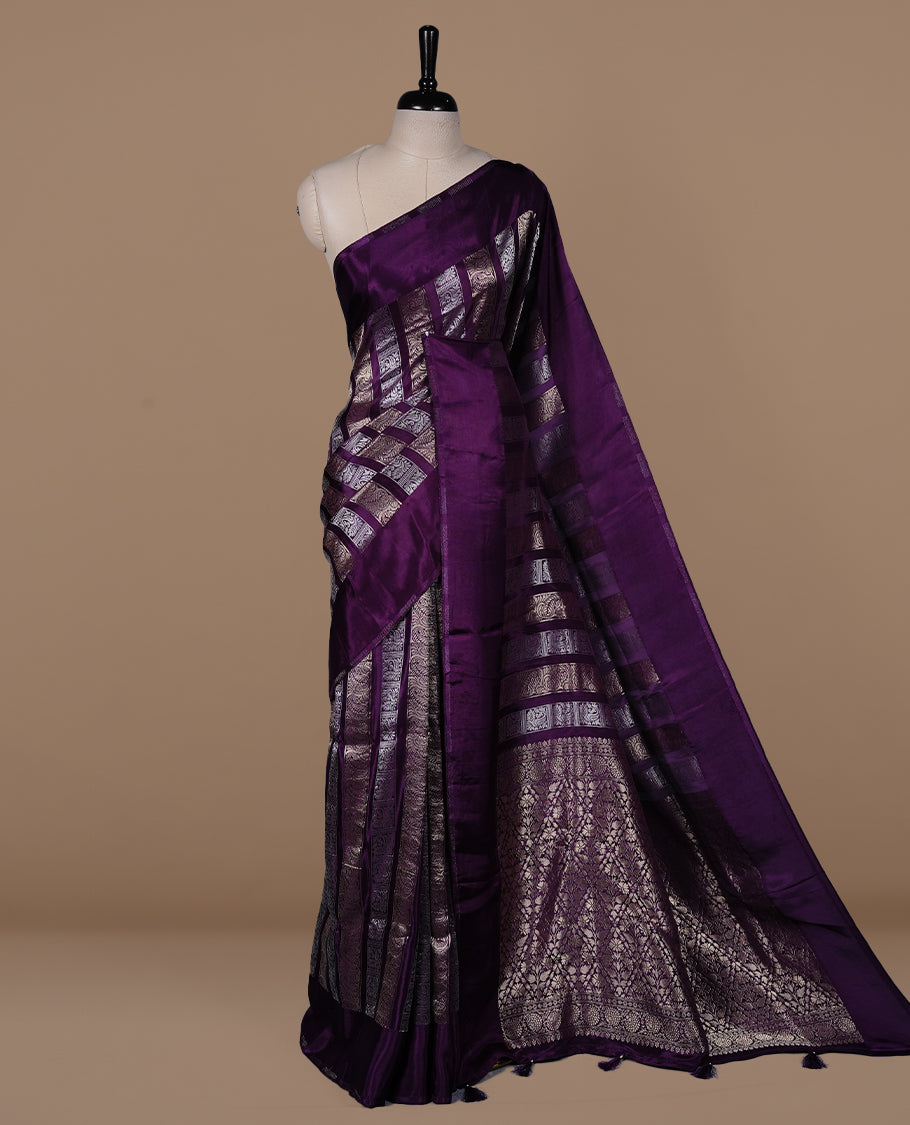 Purple colour banaras crepe saree featuring gold & silver zari design stripes on body, complemented by self colour border, paired with matching blouse piece.
