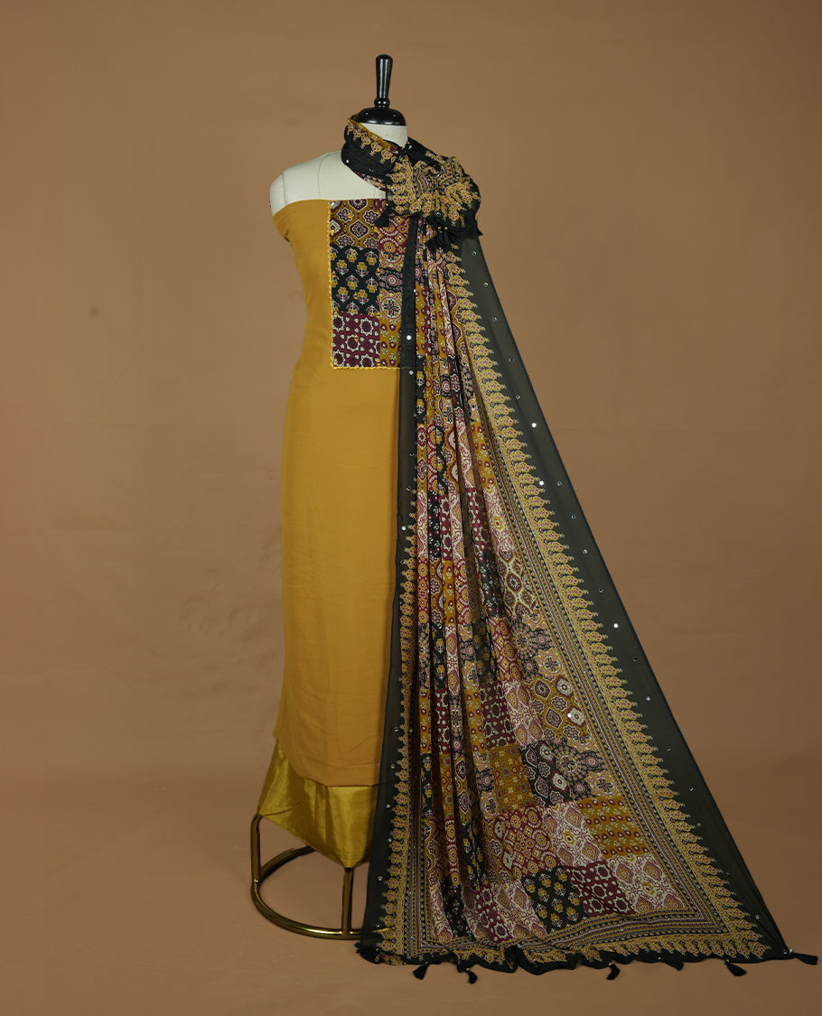 Mustard colour georgette salwar suit collection featuring plain body enhanced with elegant black bunch kalamkari print on neck yoke, detailed with subtle mirror work , paired with kalamkari printed dupatta with mirror work with santon material bottom.