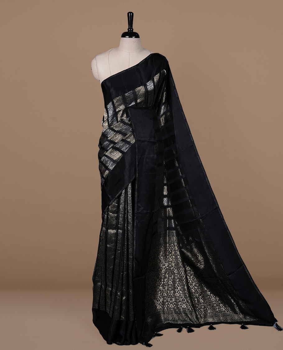 Black colour banaras crepe saree featuring gold & silver zari design stripes on body, complemented by self colour border, paired with matching blouse piece.
