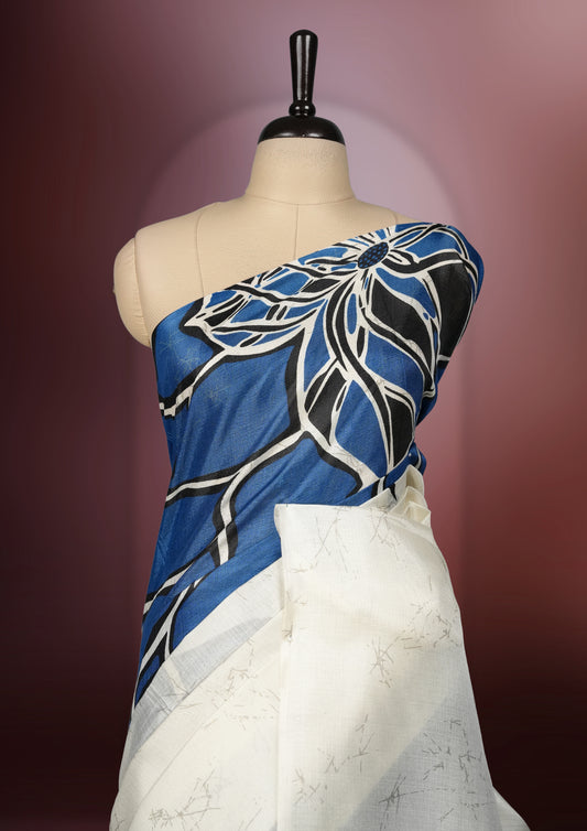 Blue and off white colour saree featuring bold floral patterns and contemporary artistry, bringing together tradition and modern style & paired with a matching blouse.