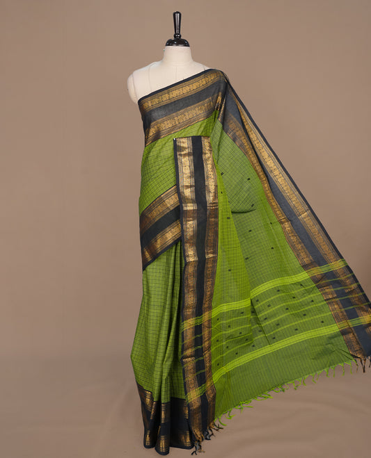 Green colour chettinad cotton saree featuring check pattern on body, complemented by contrast black with gold zari border, paired with matching blouse piece.