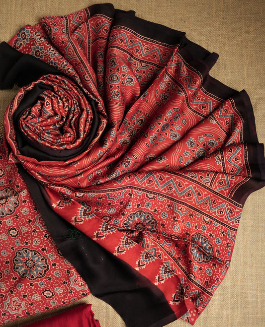 Rich Maroon colour suit material featuring traditional Ajrakh inspired prints in black and beige hues & Paired with a beautifully patterned dupatta and solid matching bottom.