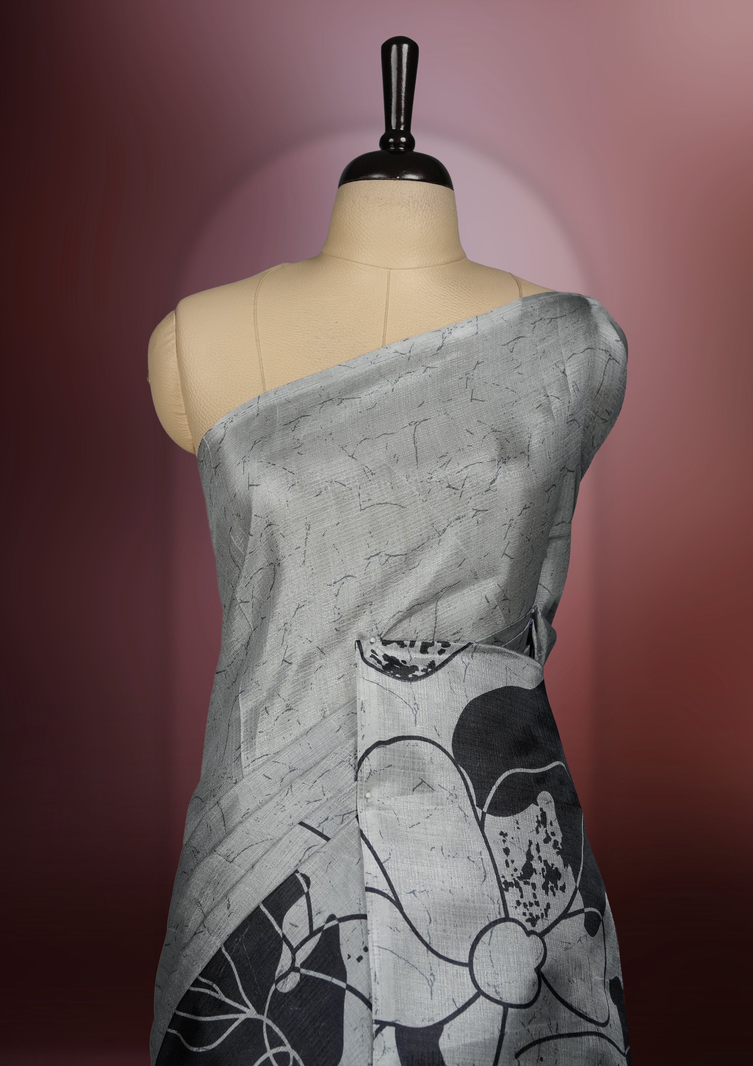 Grey colour saree with striking black floral patterns, merging modern minimalism with timeless charm & paired with a matching blouse.