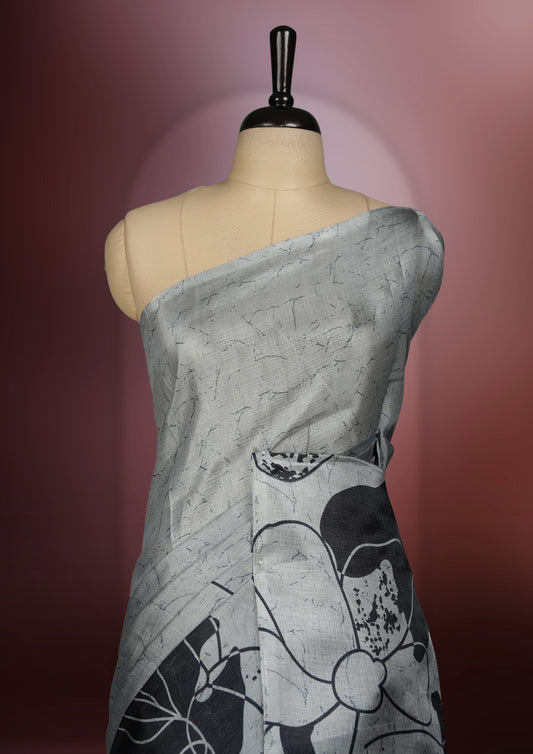 Grey colour saree with striking black floral patterns, merging modern minimalism with timeless charm & paired with a matching blouse.