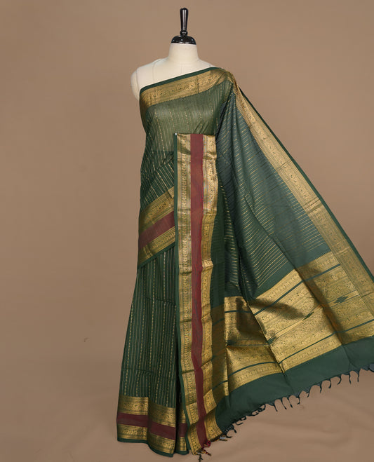 Green colour chettinad cotton saree featuring gold zari stripes on body, complemented by gold zari with maroon border, paired with matching blouse piece.