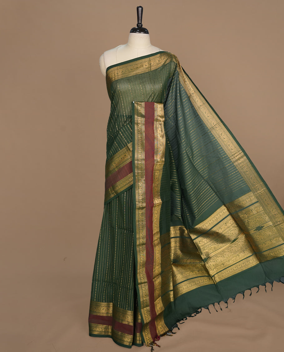 Green colour chettinad cotton saree featuring gold zari stripes on body, complemented by gold zari with maroon border, paired with matching blouse piece.