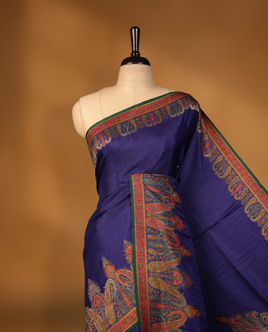 Indigo colour Pashmina silk saree densely woven with intricate multicolour floral and architectural motifs across the body, framed by an opulent arabesque border and grand storytelling pallu, paired with a matching black woven border blouse piece