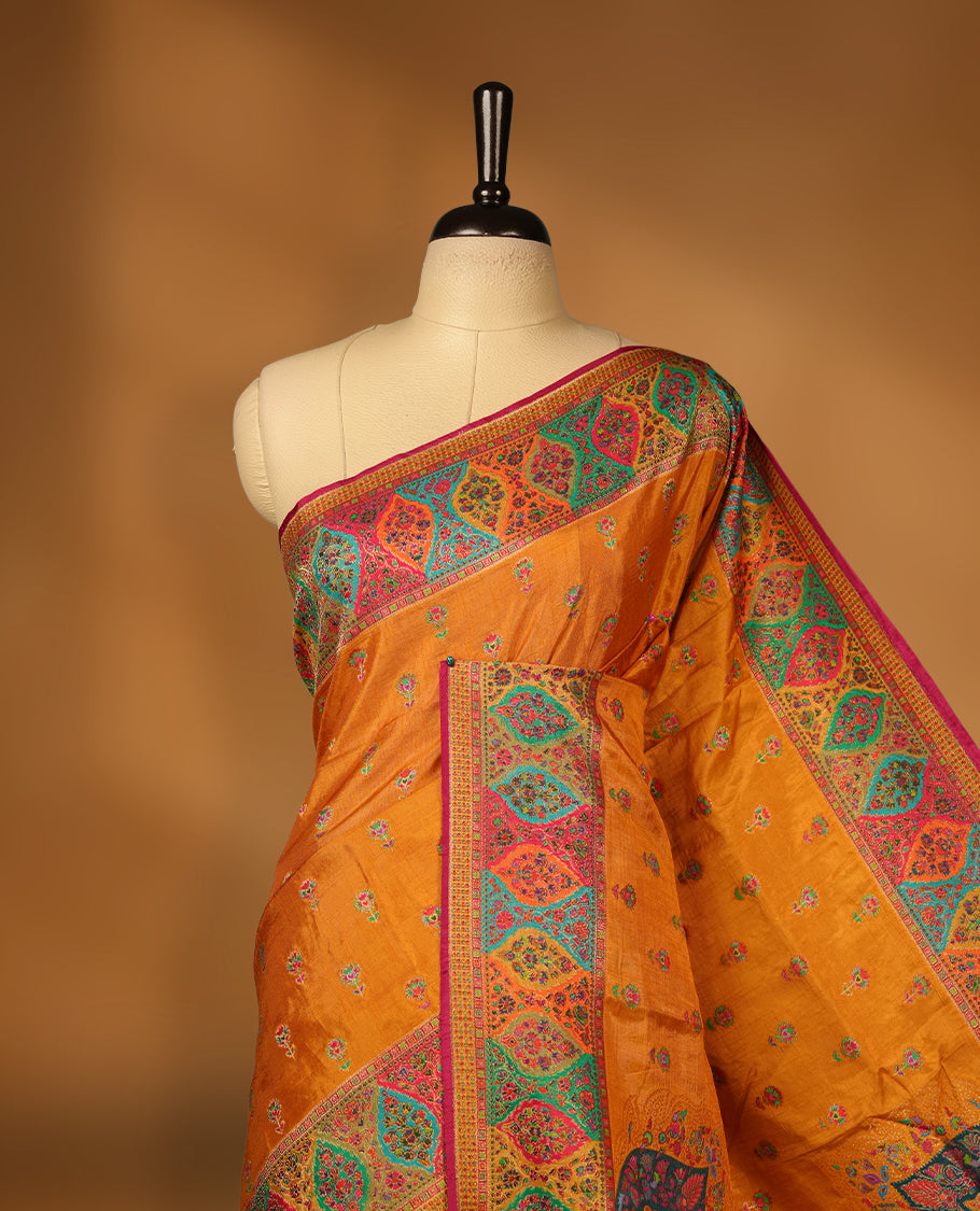 Mustard colour Pashmina silk saree densely woven with intricate multicolour floral motifs across the body, framed by an opulent arabesque border and grand storytelling pallu, paired with a matching woven border blouse piece
