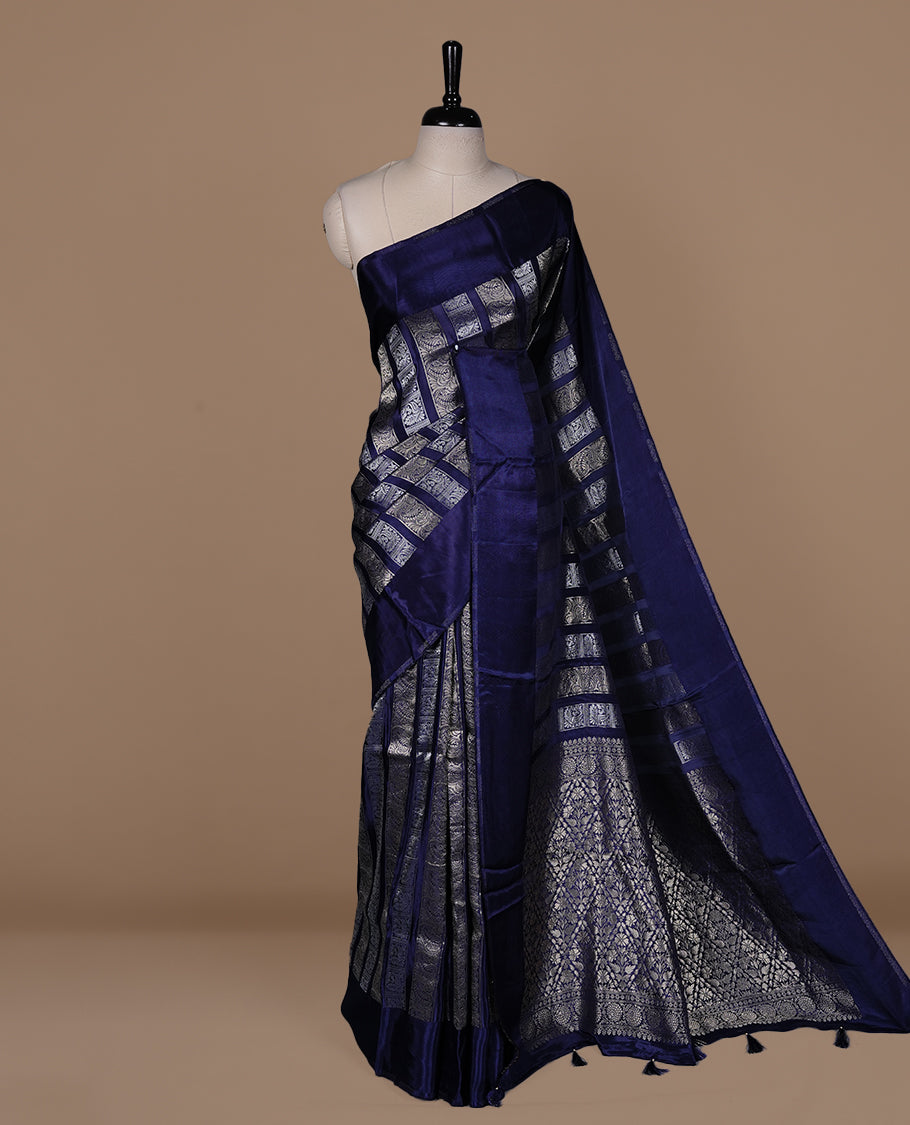 Blue colour banaras crepe saree featuring gold & silver zari design stripes on body, complemented by self colour border, paired with matching blouse piece.