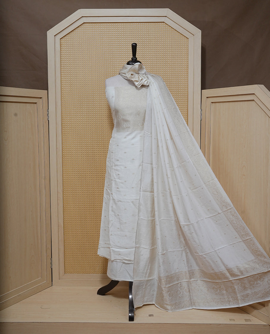 Cream colour Salwar material featuring gold zari Buttas on body & zari worked Neck Portion, paired with matching dupatta & Bottom.