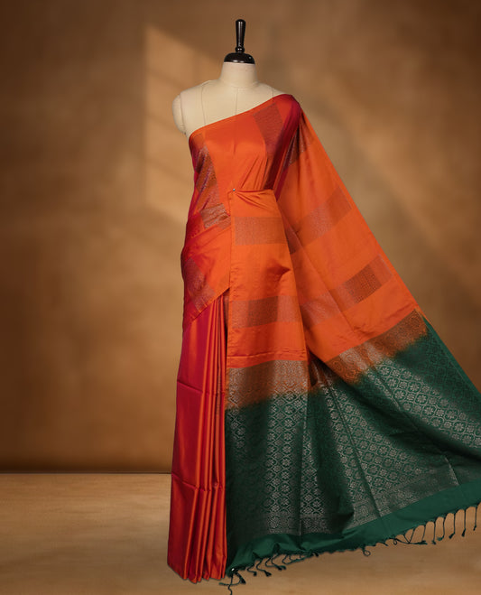 Burnt orange colour soft silk saree featuring Antique zari motifs on body with Highlighting contrast green colour pallu and paired with matching blouse piece.