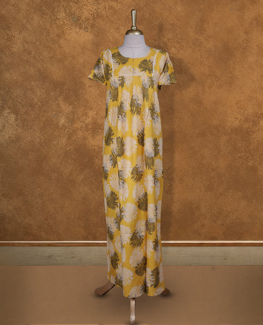 Yellow colour NStyle nighty featuring black and white leaf patterns, a round neckline with gathered detailing, short sleeves, and a full ankle-length design.