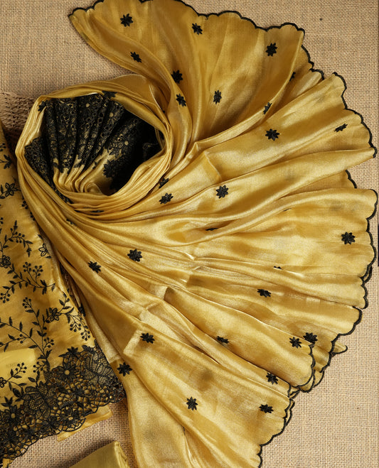 Elegant mustard yellow colour dual shaded suit material with delicate black floral embroidery and lace border & Includes matching dupatta with embroidered motifs and plain bottom fabric.