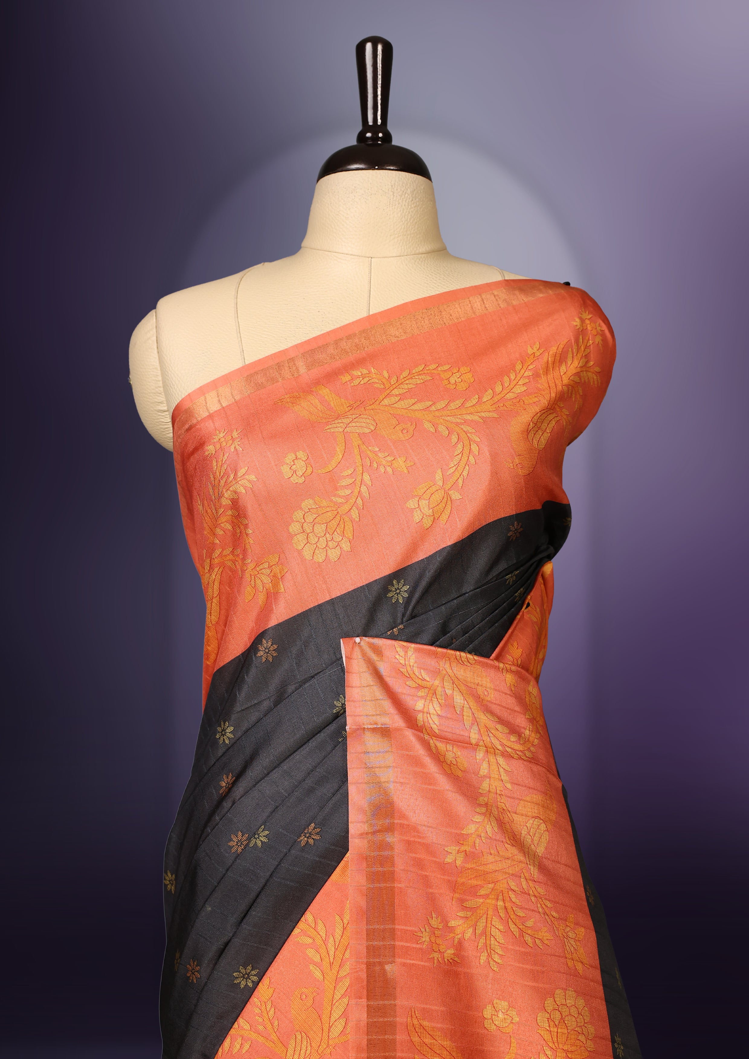 Grey & orange saree adorned with golden buttas, complemented by a rich orange zari border and pallu with floral motifs, paired with a matching blouse.