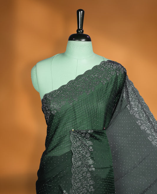 Deep bottle-green chiffon designer saree adorned with delicate white stone work across the body, enhanced with a heavy scalloped stone border and pallu. Paired with a matching stone-detailed blouse.