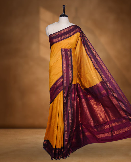 Mustard colour mixed Kalyani cotton saree with subtle zari motifs, maroon zari border and rich traditional pallu, paired with a matching blouse.