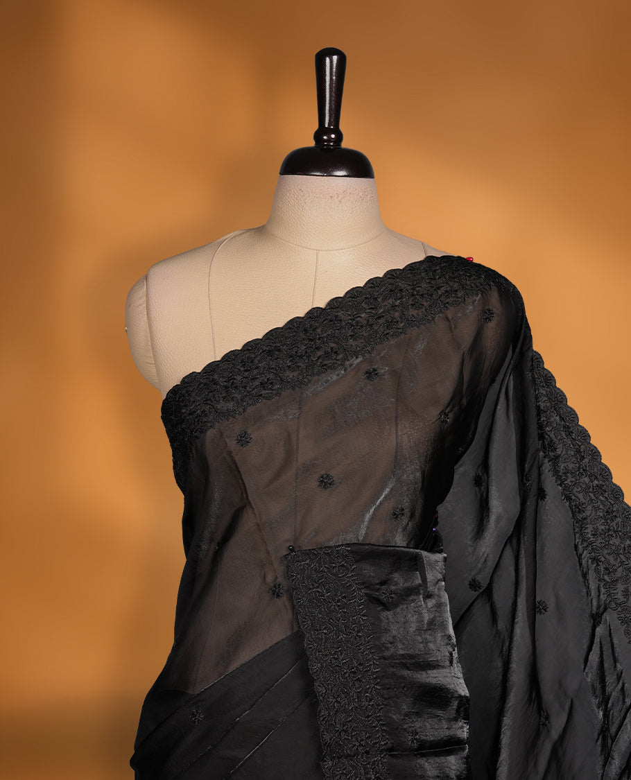 Black colour organza saree featuring self colour thread embroidery work on body and border, paired with matching blouse piece.