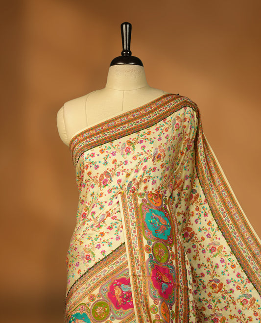 Ivory colour Pashmina silk saree densely woven with intricate multicolour floral kodi pattern across the body, framed by an opulent arabesque border and grand storytelling pallu, paired with a matching woven border blouse piece