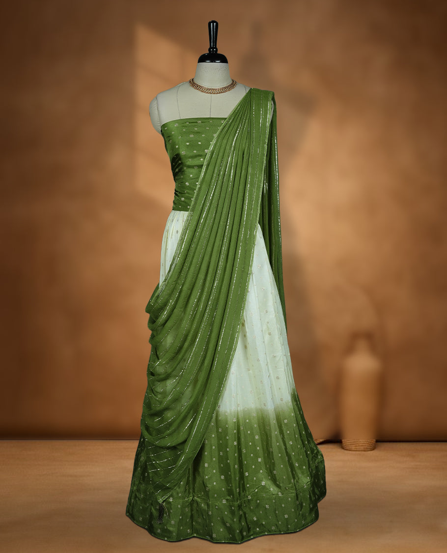 Off white semi banaras semi stitched dhavani set featuring gold zari motifs and contrast green colour border, unstitched gold zari blouse piece and matching Duptta with gold zari stripes.
