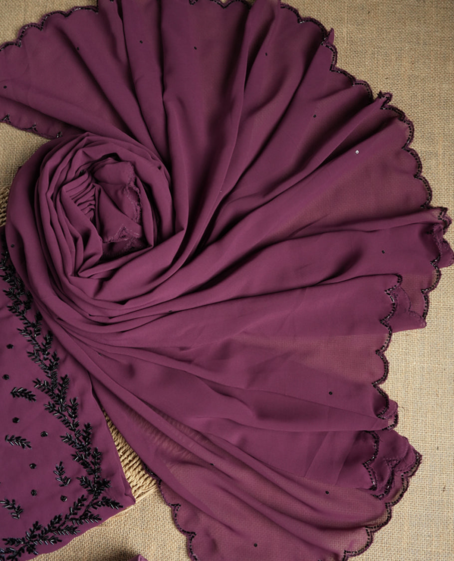 Elegant dark mauve colour suit material adorned with intricate black cut beads work, exuding sophisticated charm & paired with a soft dupatta and a matching plain bottom.