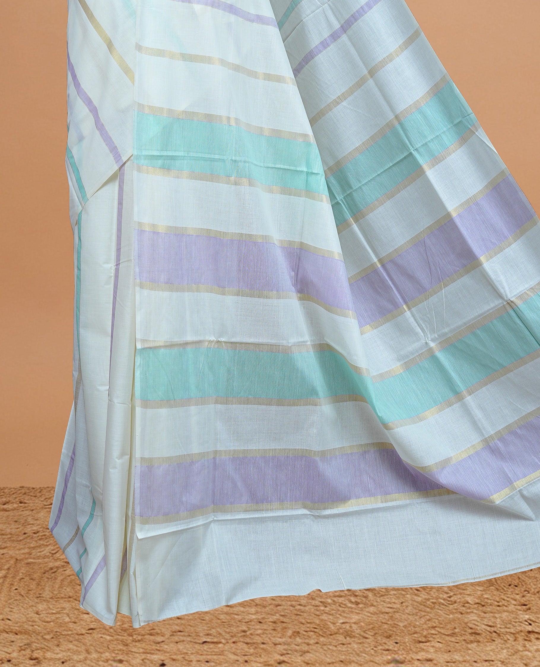 Cream Colour Cotton Kerala Saree Featuring Green & Light Purple Strips On The Body & Pallu, Paired With A Matching Blouse Piece.