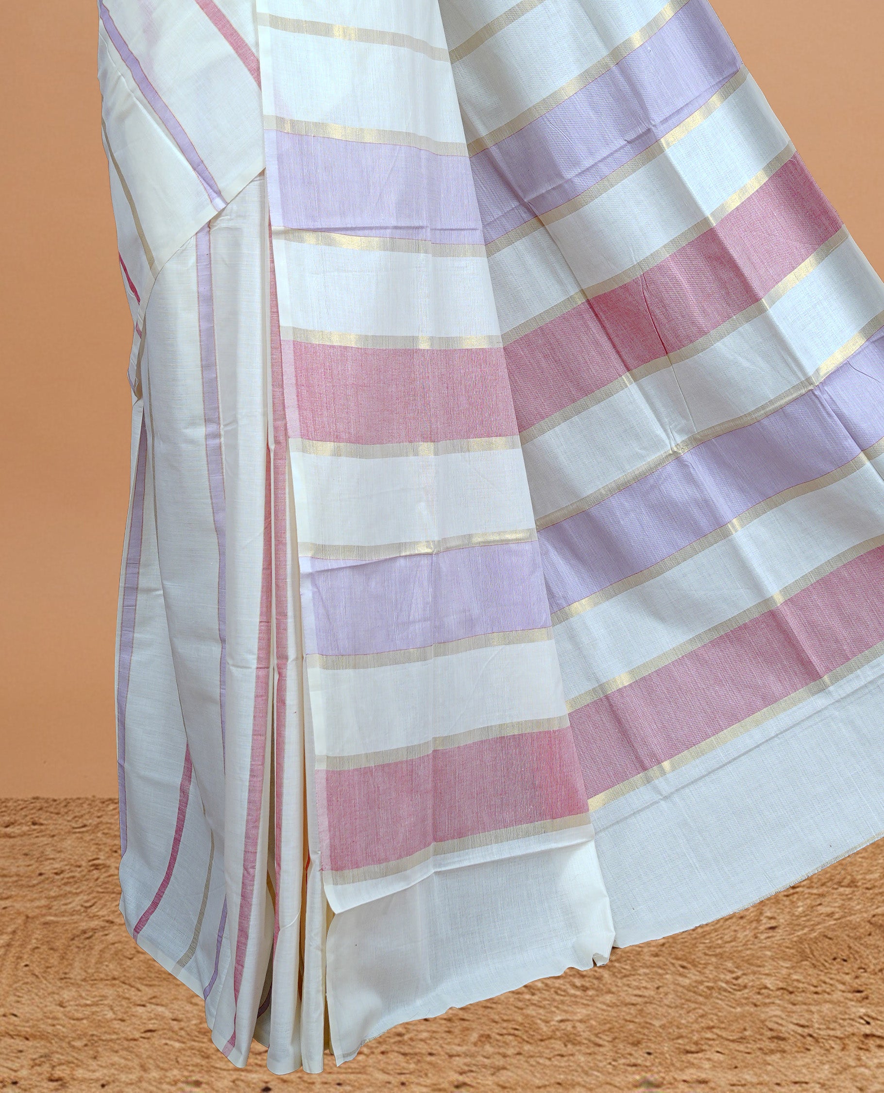 Cream Colour Cotton Kerala Saree Featuring  Pastel Red &   Lavender Strips On The Body & Pallu, Paired With A Matching Blouse Piece.