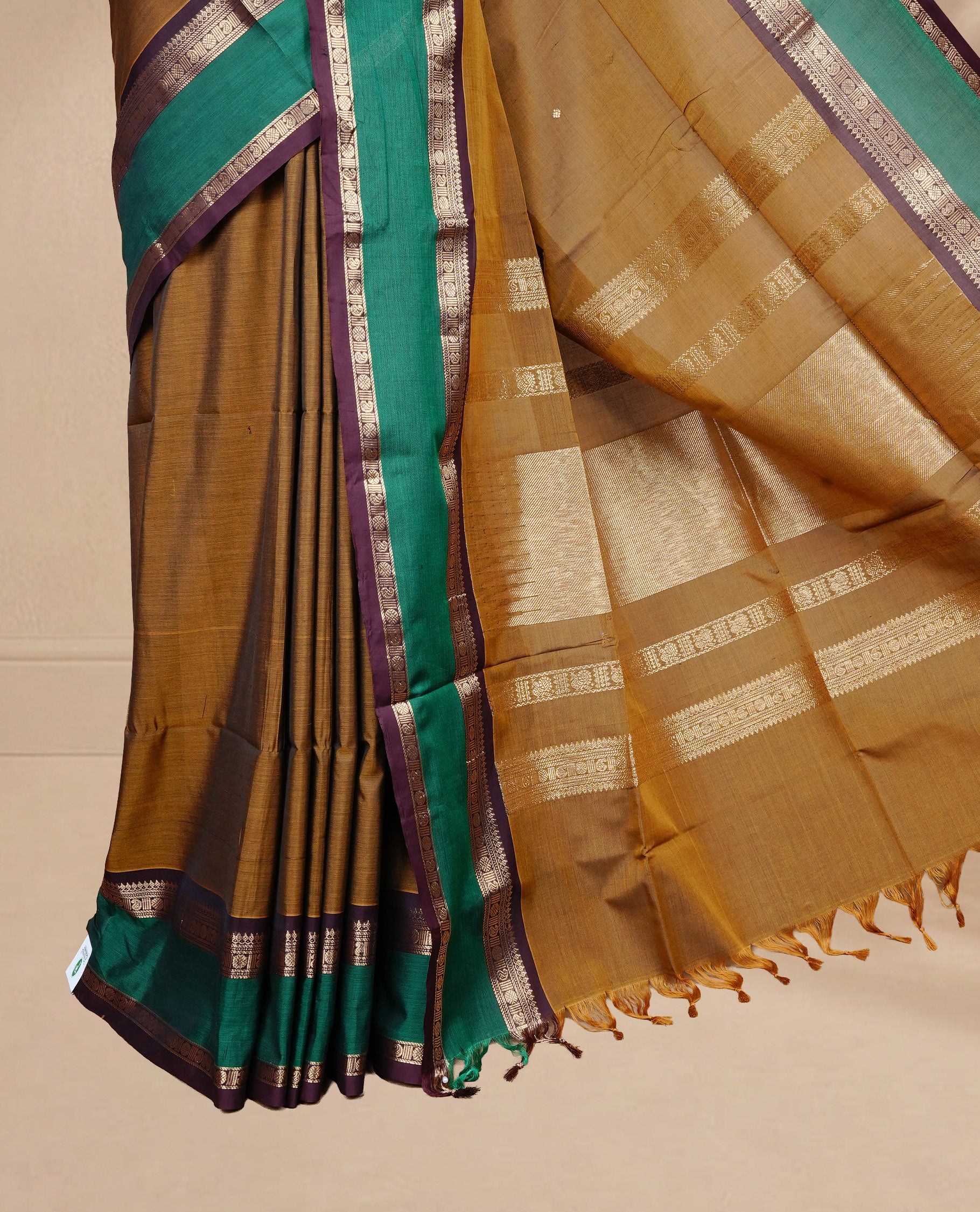 Olive colour Chettinad Silk cotton saree featuring Elegant body, complemented by Contrast Green & Chocolate colour with Gold zari border, paired with matching blouse piece.