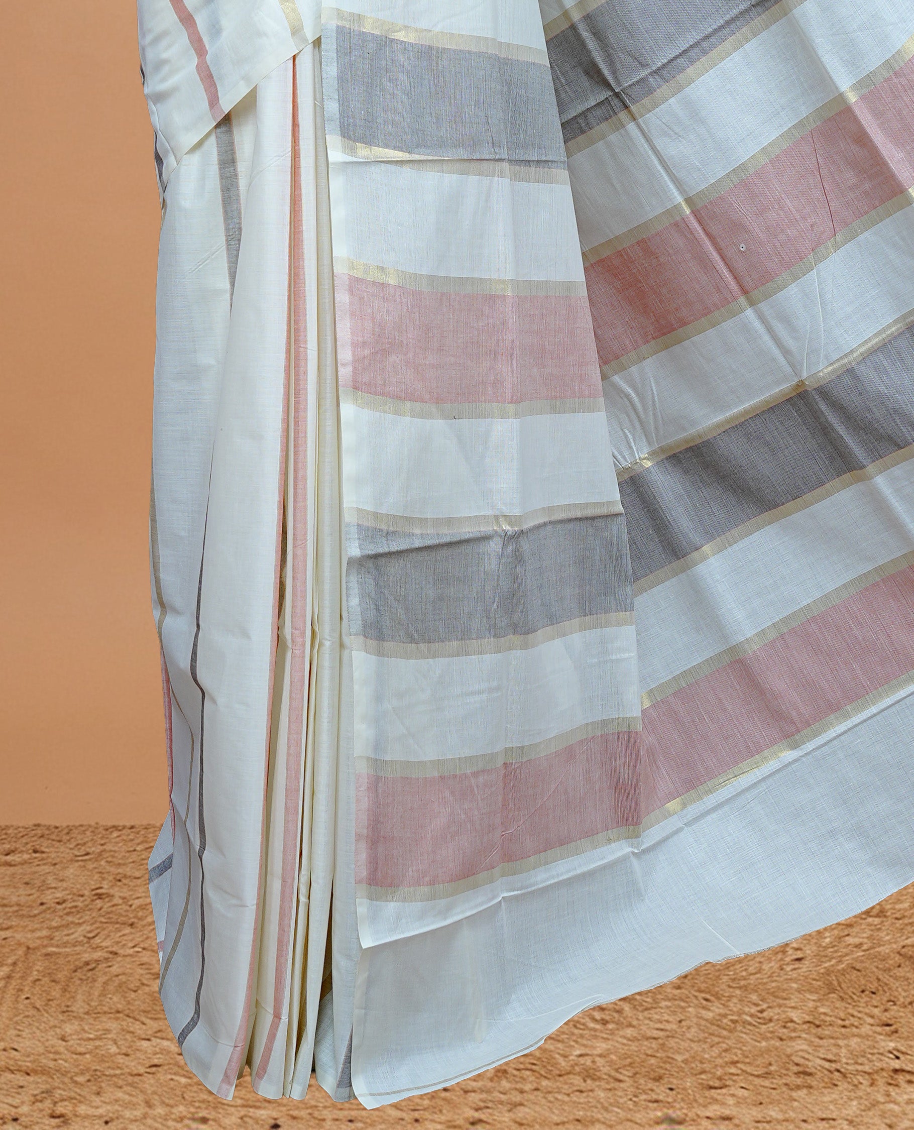 Cream Colour Cotton Kerala Saree Featuring Gray & Light Red Strips On The Body & Pallu, Paired With A Matching Blouse Piece.