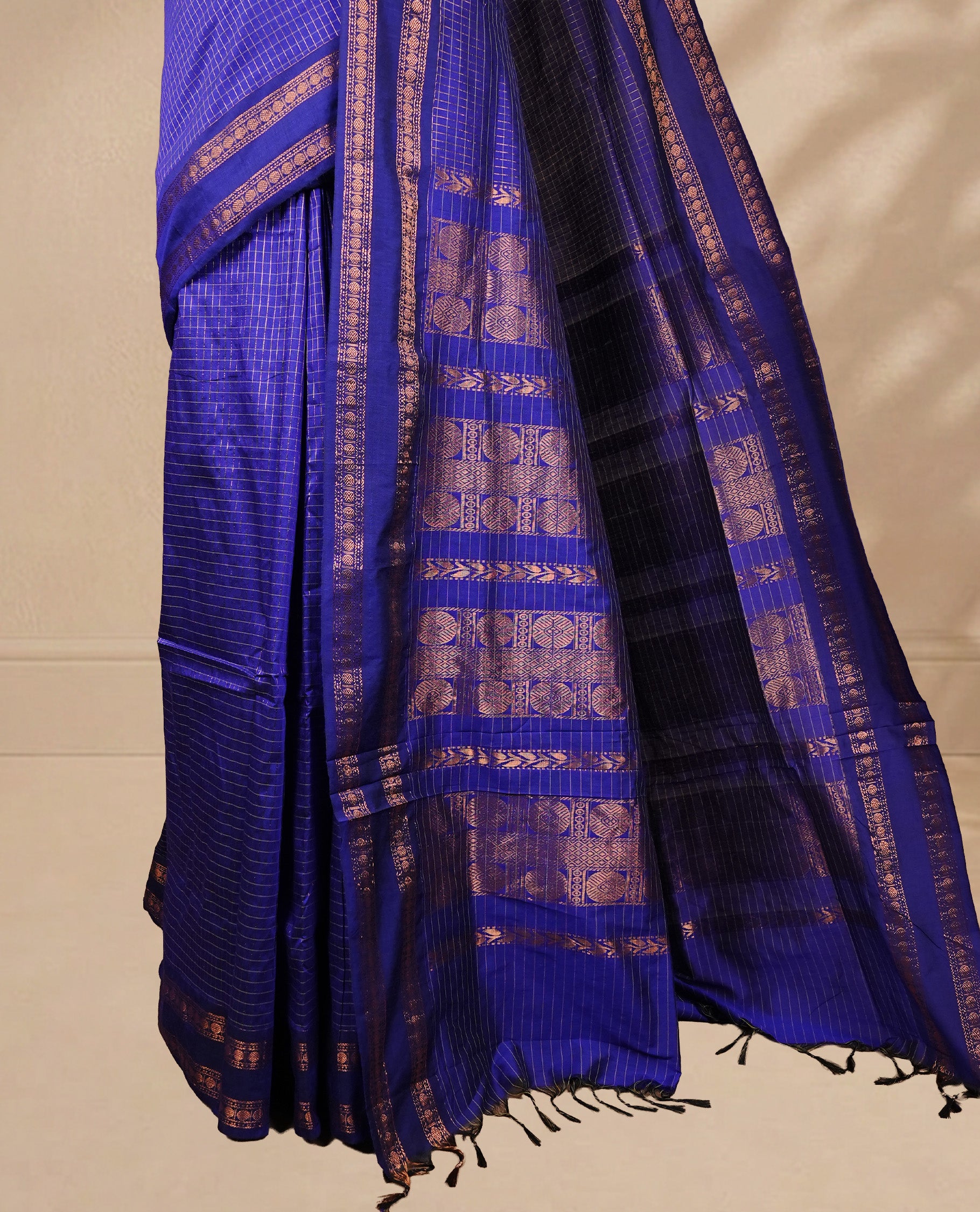 Navy blue colour kalyani cotton saree featuring gold zari strip pattern on body, complemented by self colour with Antique zari border, paired with matching blouse piece.