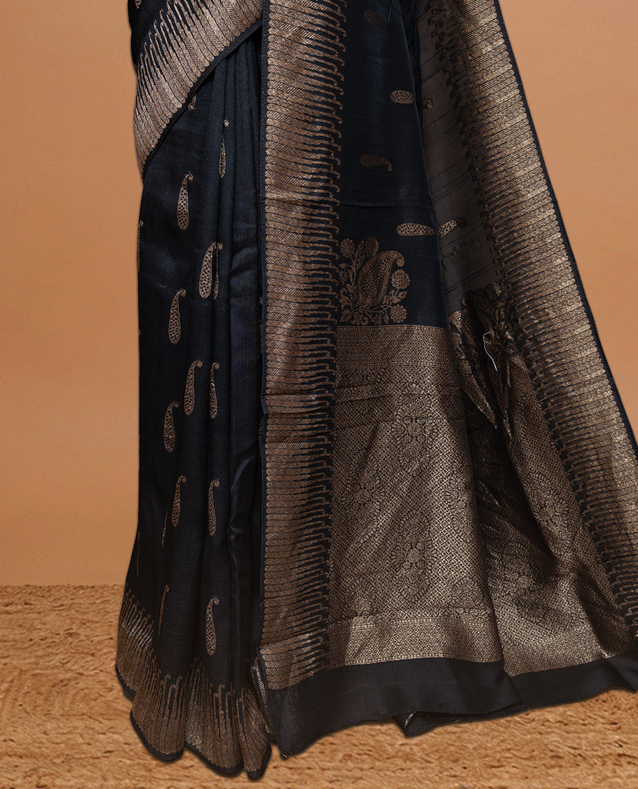 Black colour Semi Banaras Tussar Georgette Featuring Gold zari Leaf pattern on body, Finished with Gold zari border and paired with matching blouse piece.