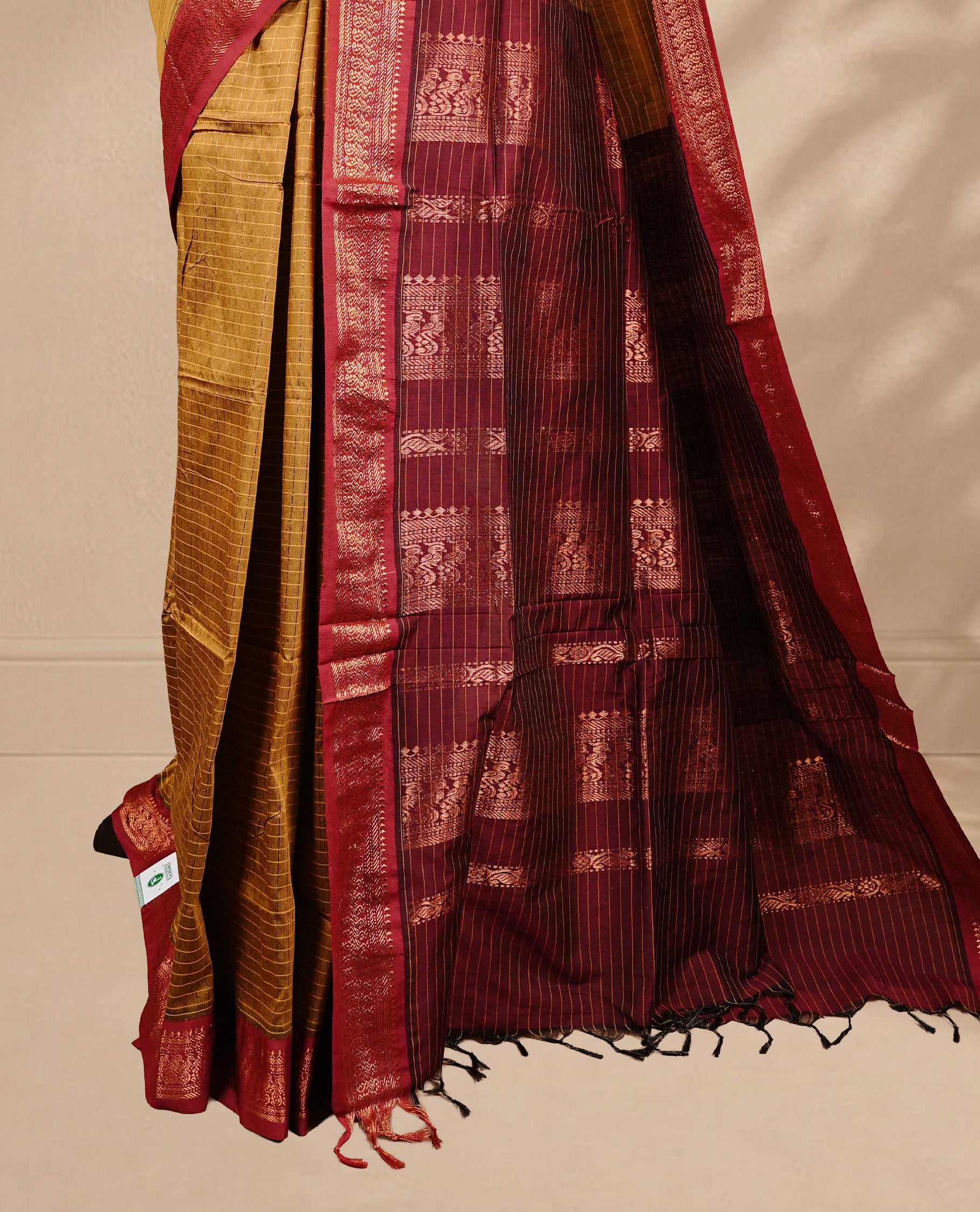 Mustard colour kalyani cotton saree featuring antique zari check pattern on body, complemented by Maroon colour with Antique zari border, paired with matching blouse piece.