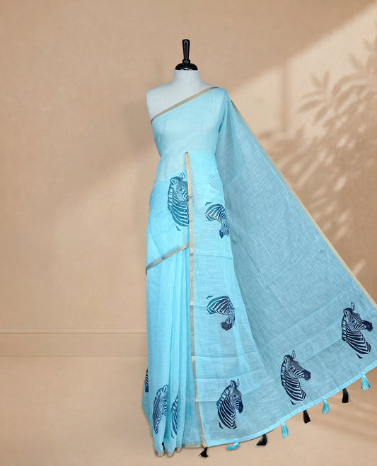 Blue semi linen saree featuring an elegant zebra print all over the body, highlighted with a delicate tissue border and paired with a matching blouse piece.