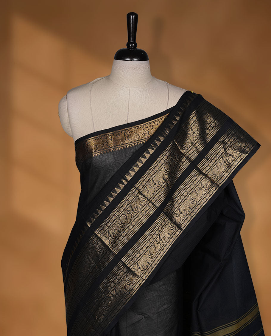 Black colour chettinad cotton saree featuring plain body, self colour with traditional gold zari border paired with matching blouse.