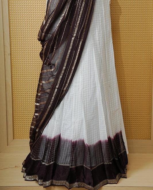 Off white colour Semi stitched dhavani set featuring Gold zari check pattern with contrast Chocolate colour border skirt, paired with matching blouse & dupatta.