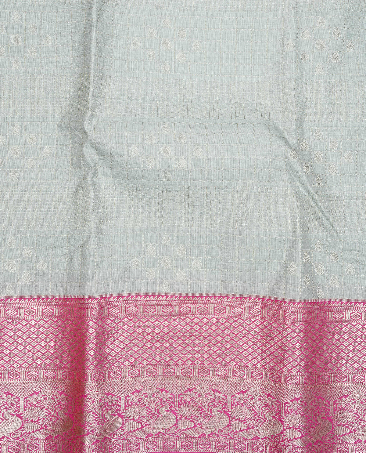 Silver grey colour semi wedding silk saree featuring silver zari checks with motifs on body,contrast magenta pink colour with peacock traditional border on body, rich pallu comes with matching blouse piece