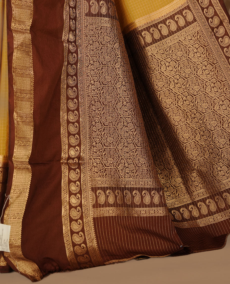 Yellow colour semi georgette saree featuring gold zari check pattern on body, complemented by contrast chocolate colour with zari border, paired with matching blouse piece.
