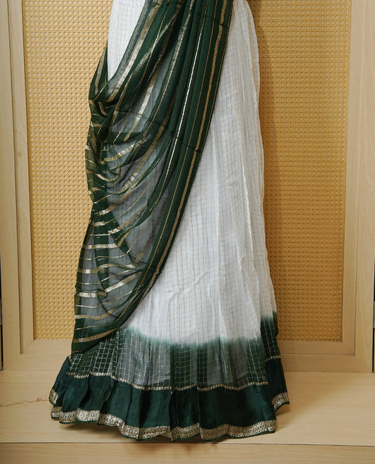Off white colour Semi stitched dhavani set featuring Gold zari check pattern with contrast Bottle green border skirt, paired with matching blouse & dupatta.