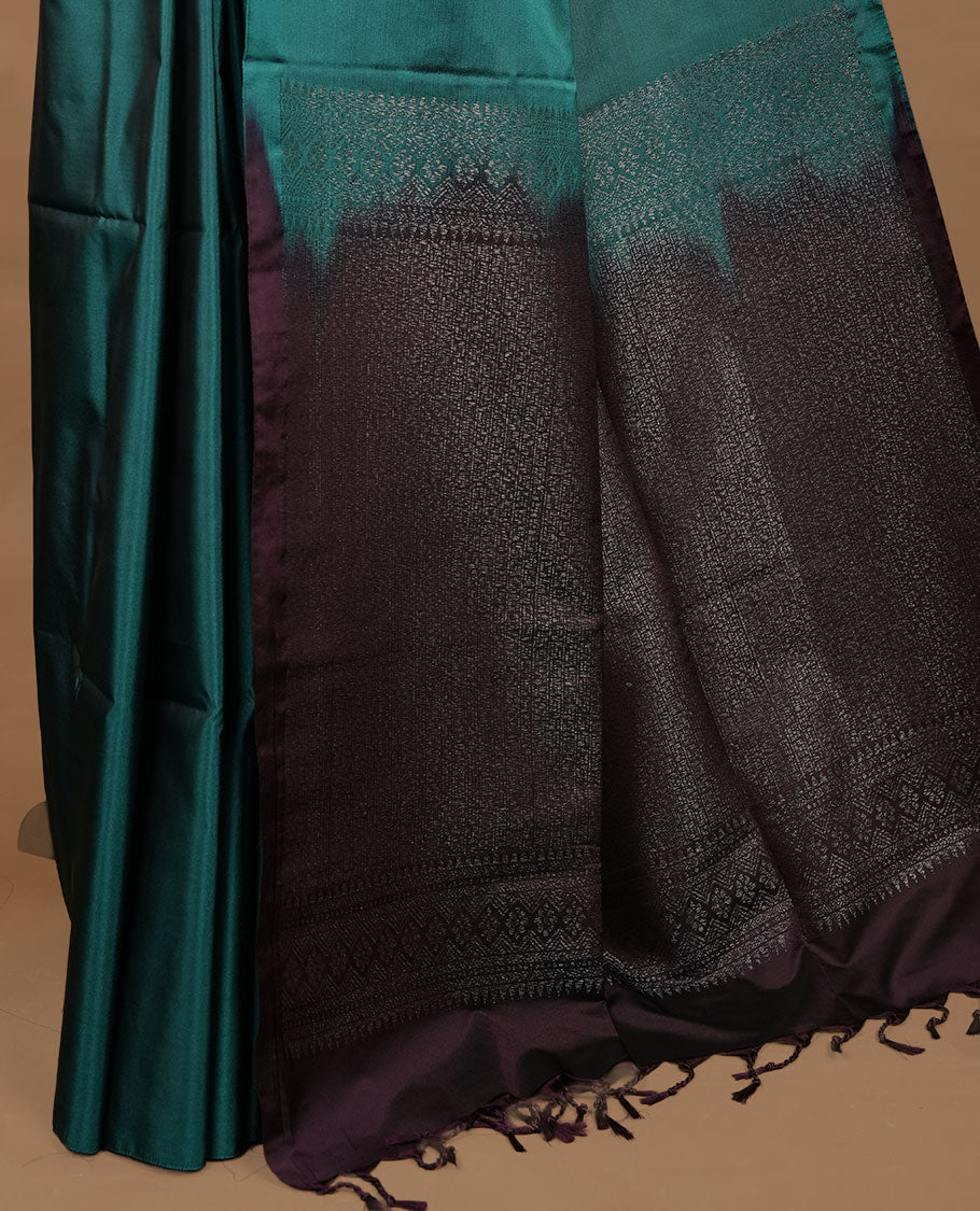 Green colour soft silk saree features a sleek borderless design with intricate antique zari motifs, flowing into a striking contrast Tyrian purple pallu and a matching blouse piece.