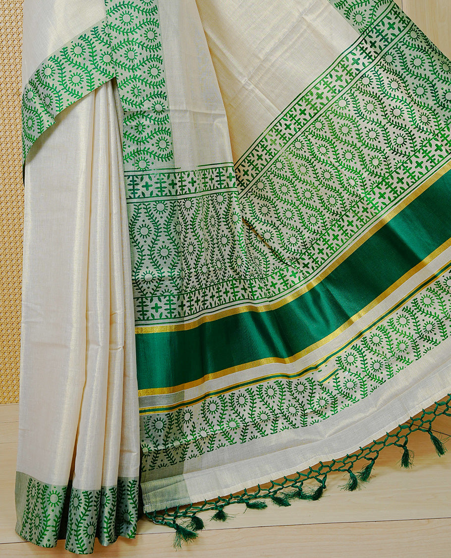 Cream Colour Tissue Kerala Saree Featuring a Plain Body, Enhanced with Green Block  Printed Borders, a Green and Gold Zari Pallu, Green Tassels, and a Matching Blouse Piece.
