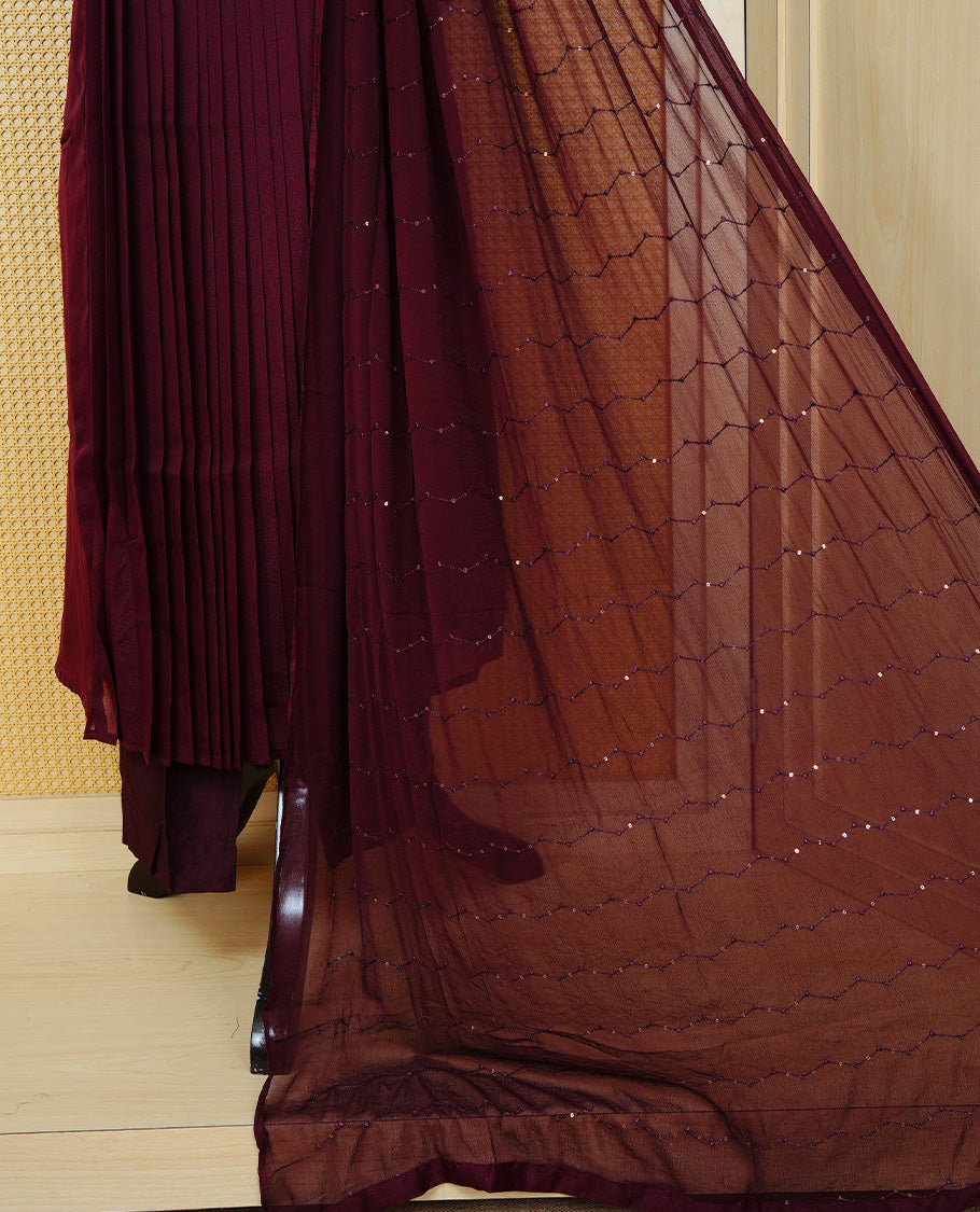 Dark maroon colour churidar set with bead & thread embroidery on the V-neckline, paired with a matching embellished dupatta and solid pants.