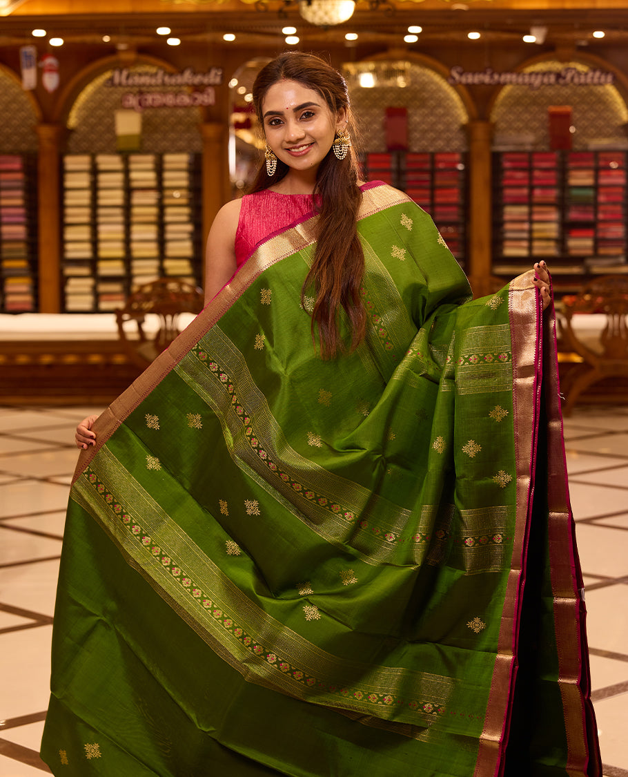 Vibrant parrot green colour Kancheepuram silk saree adorned with delicate gold zari motifs across the body, beautifully complemented by a classic zari border with hints of contrast, styled with a blouse