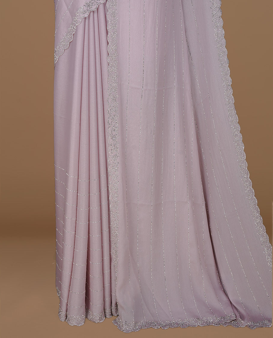 Light pink colour designer saree featuring white stone stripes on body, highlighting white stone with scalp border, paired with matching blouse piece.