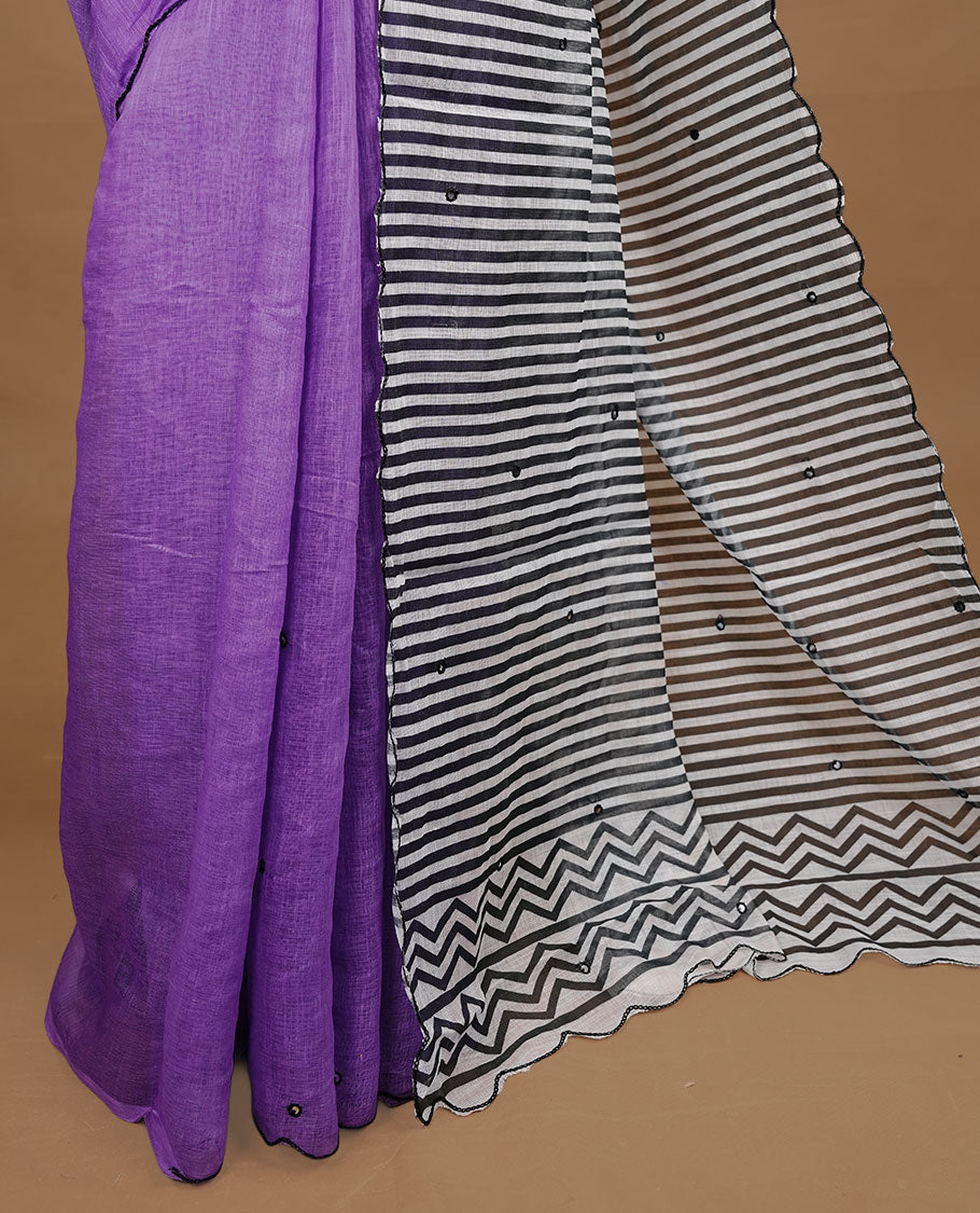 Violet colour Semi Linen saree featuring mirror work with intricate thread detailing, enhanced by a stylish scallop border. Comes without a blouse piece.