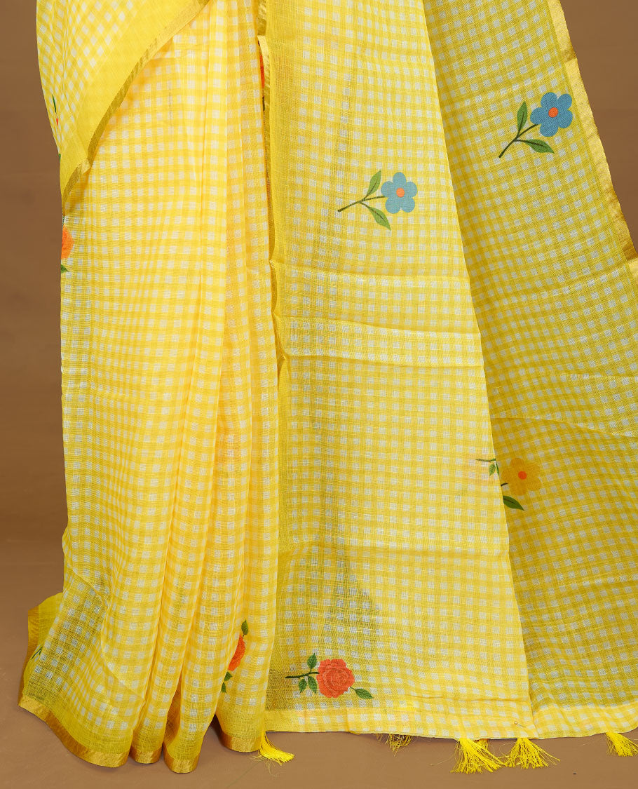 Yellow colour Semi Linen saree featuring a stylish check pattern adorned with floral prints on the body, enhanced by a small gold border, paired with a matching blouse piece.