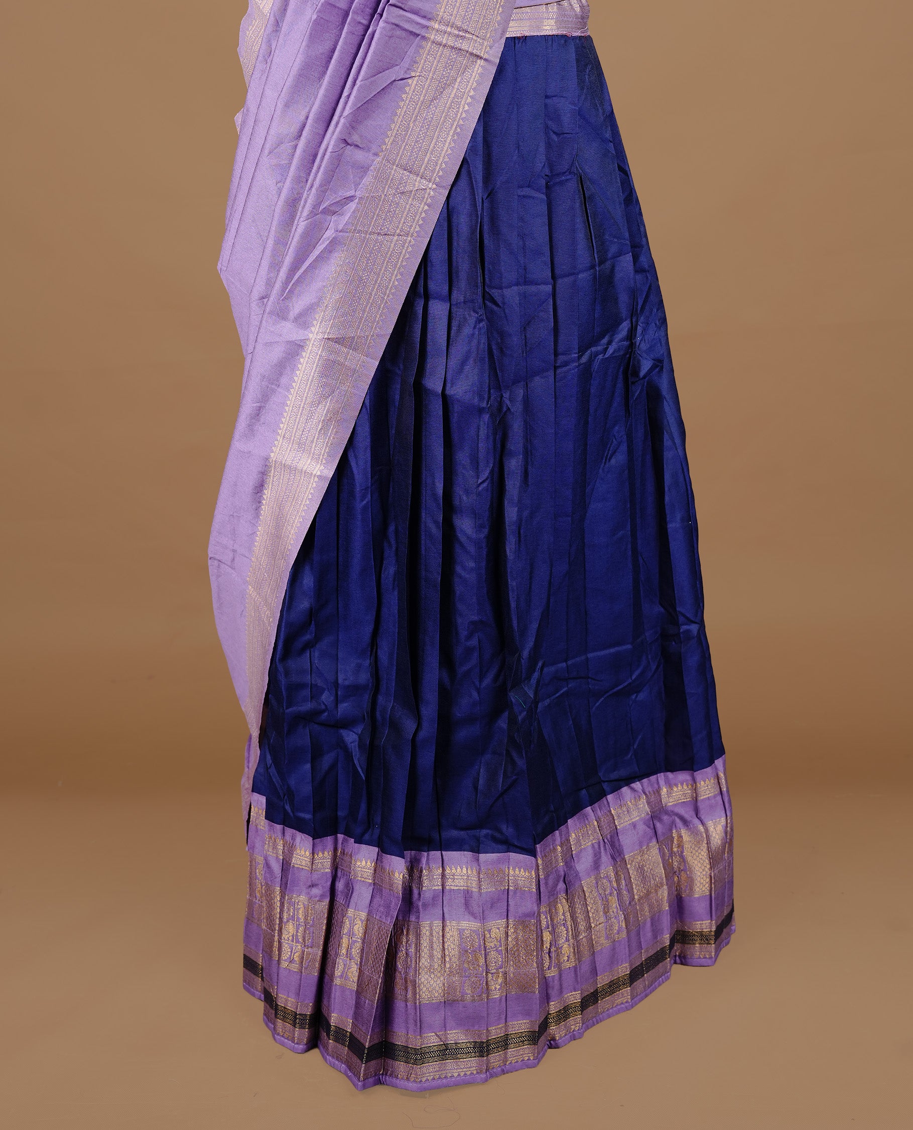 Navy blue colour semi stitched Half saree featuring contrast lavender colour with gold zari traditional border skirt, paired with matching zari border dupatta, unstitched blouse piece