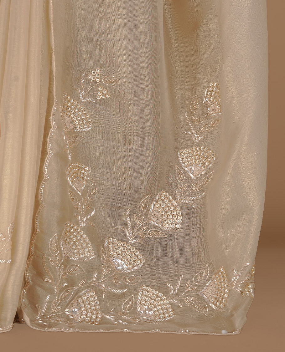 Beige colour net organza saree featuring thread, sequins, cut beats worked on body, highlighting scalp border, paired with matching blouse piece.