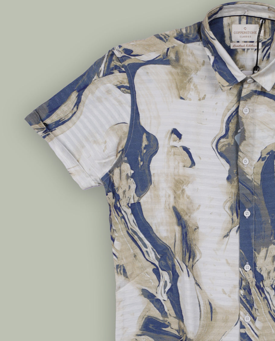 Off white colour shirt features a bold abstract print in blue and white tones, With short sleeves and a button-down front, its made from textured fabric, offering a stylish and modern look.